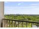 Balcony view with wood-look tile and painted wood railing overlooking lush trees and the skyline at 145 15Th Ne St # 1209, Atlanta, GA 30309