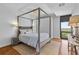 Elegant bedroom with a four-poster bed, wood floors, and large window at 145 15Th Ne St # 1209, Atlanta, GA 30309