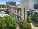 Exterior image showing the high-rise apartment building surrounded by large leafy trees at 145 15Th Ne St # 1209, Atlanta, GA 30309