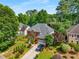 Aerial view of a two-story brick home with mature landscaping and a private, wooded backyard at 1490 Rivershyre Pkwy, Lawrenceville, GA 30043