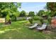 Well-maintained backyard with lounge chairs, stone retaining walls, and mature trees at 1490 Rivershyre Pkwy, Lawrenceville, GA 30043