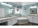 Well-appointed bathroom with a soaking tub and dual sinks set in marble countertops at 1490 Rivershyre Pkwy, Lawrenceville, GA 30043