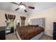 Comfortable bedroom with patterned bedding, a ceiling fan, and windows with plaid valances at 1490 Rivershyre Pkwy, Lawrenceville, GA 30043