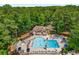 Beautiful swimming pool area with lounge chairs and umbrellas surrounded by mature trees at 1490 Rivershyre Pkwy, Lawrenceville, GA 30043