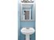 Cozy bathroom features blue walls, a pedestal sink, and a well-lit mirror for a clean, classic look at 1945 Kevin Se Dr, Conyers, GA 30013