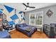 Stylish bedroom featuring a cool accent wall, ceiling fan, and bright natural light at 1945 Kevin Se Dr, Conyers, GA 30013