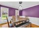 The dining room showcasing a modern light fixture, large windows, and a rich purple accent wall at 1945 Kevin Se Dr, Conyers, GA 30013