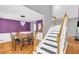 Elegant dining room with hardwood floors, a stylish chandelier, and bold purple accent wall at 1945 Kevin Se Dr, Conyers, GA 30013
