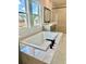 Modern bathroom features a soaking tub with black fixtures and marble surround at 2455 Bleckley Pl, Cumming, GA 30041
