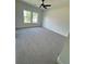Bright bedroom featuring a ceiling fan, plush carpet, and large windows overlooking the backyard at 2455 Bleckley Pl, Cumming, GA 30041