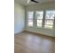 Bright bedroom featuring three large windows and hardwood floors that offer plenty of natural light at 2455 Bleckley Pl, Cumming, GA 30041