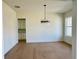 Bright dining room featuring hardwood floors, modern chandelier, and doorway to kitchen at 2455 Bleckley Pl, Cumming, GA 30041