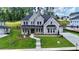 Beautiful two-story home with a light brick exterior, lush lawn, and dark metal awning accents at 2455 Bleckley Pl, Cumming, GA 30041