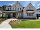 Beautiful two-story brick home with well-manicured lawn, covered front porch, and professionally landscaped yard at 2455 Bleckley Pl, Cumming, GA 30041