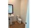 Clean powder room with a pedestal sink, a framed mirror and updated toilet at 2455 Bleckley Pl, Cumming, GA 30041