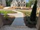 A view of the front yard and sidewalk leading to an elegant brick house at 2455 Bleckley Pl, Cumming, GA 30041