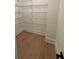 Organized walk-in closet boasts hardwood floors and customizable shelving system at 2455 Bleckley Pl, Cumming, GA 30041