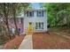 Charming home with light grey brick, blue shutters, a bright yellow door and mature trees at 2780 Northwood Court Sw Ct, Marietta, GA 30060