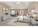 The staged primary bedroom boasts a tray ceiling, neutral decor, and ample natural light at 1056 Shadow Lake Dr, Lithonia, GA 30058