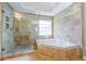 Walk-in shower and large soaking tub with decorative tile at 1547 Grove Arbor Ter, Dacula, GA 30019
