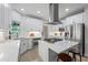 Bright kitchen features white cabinets, stainless appliances, and an island with seating at 1547 Grove Arbor Ter, Dacula, GA 30019