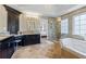 Bathroom with a soaking tub, a glass enclosed shower, and a granite topped vanity with dark cabinets at 1547 Grove Arbor Ter, Dacula, GA 30519