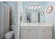 Well-lit bathroom featuring double sinks and a toilet with tiled shower at 1547 Grove Arbor Ter, Dacula, GA 30519