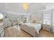 Bright bedroom featuring tray ceiling, chandelier, a large bed, natural light, and tasteful decor at 1547 Grove Arbor Ter, Dacula, GA 30519