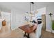 Open dining room with hardwood floors, modern lighting, and access to the living room at 1547 Grove Arbor Ter, Dacula, GA 30519