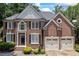 Charming brick home featuring a well-manicured lawn and a two-car garage at 1547 Grove Arbor Ter, Dacula, GA 30519