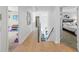 Bright hallway showcasing hardwood floors, art, and open doorways to a play room and carpeted bedroom at 1547 Grove Arbor Ter, Dacula, GA 30519