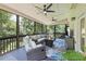 Serene screened-in porch featuring comfortable seating, ceiling fans, and views of the wooded backyard at 1547 Grove Arbor Ter, Dacula, GA 30519