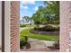 Inviting view of beautifully landscaped front yard from a brick-framed doorway at 1547 Grove Arbor Ter, Dacula, GA 30519