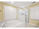 Bright bathroom featuring a soaking tub with a shower head and a glass-door walk-in shower with nice bright windows at 280 W Knight W Rd, Mcdonough, GA 30252