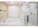Bright bathroom featuring a soaking tub with a shower head and a glass-door walk-in shower at 280 W Knight W Rd, Mcdonough, GA 30252