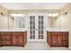 Stylish bathroom featuring dual vanities, elegant mirrors and convenient access to a walk-in shower behind French doors at 280 W Knight W Rd, Mcdonough, GA 30252