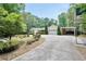 Inviting single-story home with a well-manicured lawn, a curved driveway, and a two-car garage with car port at 280 W Knight W Rd, Mcdonough, GA 30252