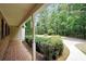Welcoming front porch with brick and concrete, offering a serene view of the lush front yard and garden at 280 W Knight W Rd, Mcdonough, GA 30252