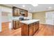 Well-equipped kitchen with wooden cabinets, granite countertops, an island, and hardwood floors, perfect for cooking at 280 W Knight W Rd, Mcdonough, GA 30252