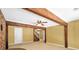 Living room featuring exposed wood beams, a brick accent wall, and access to the stairwell at 280 W Knight W Rd, Mcdonough, GA 30252