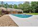 Refreshing backyard pool, complemented by a spacious deck, lounge chairs, and beautiful landscaping, ideal for relaxation at 280 W Knight W Rd, Mcdonough, GA 30252