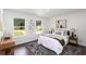 Well-lit bedroom offers two large windows, hardwood floors, a comfortable bed, and contemporary decor at 932 Brian Ln, Forest Park, GA 30297