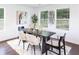 Bright dining area featuring a stylish dark wood table, modern decor, and three windows at 932 Brian Ln, Forest Park, GA 30297