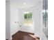 Well-lit laundry area with gleaming wood floors, a window for natural light, and convenient hookups for modern appliances at 932 Brian Ln, Forest Park, GA 30297