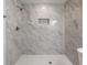 Beautifully tiled shower with marble-look features a built-in niche and modern fixtures for a luxurious experience at 932 Brian Ln, Forest Park, GA 30297