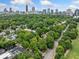 Aerial view of a neighborhood showcasing lush greenery, surrounding trees, and the Atlanta skyline in the distance at 411 10Th Ne St # 6, Atlanta, GA 30309