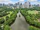 Scenic aerial view captures a calm lake and verdant park area with the Atlanta skyline in the background at 411 10Th Ne St # 6, Atlanta, GA 30309