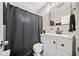 Well-lit bathroom features a white vanity, modern fixtures, and a dark shower curtain at 411 10Th Ne St # 6, Atlanta, GA 30309