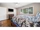 Bedroom with hardwood floors, ceiling fan, a large window, and a dark wood bedframe with a mounted TV at 411 10Th Ne St # 6, Atlanta, GA 30309