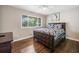 Bedroom featuring hardwood floors, a ceiling fan, a large window, and a decorative dark wood bedframe at 411 10Th Ne St # 6, Atlanta, GA 30309